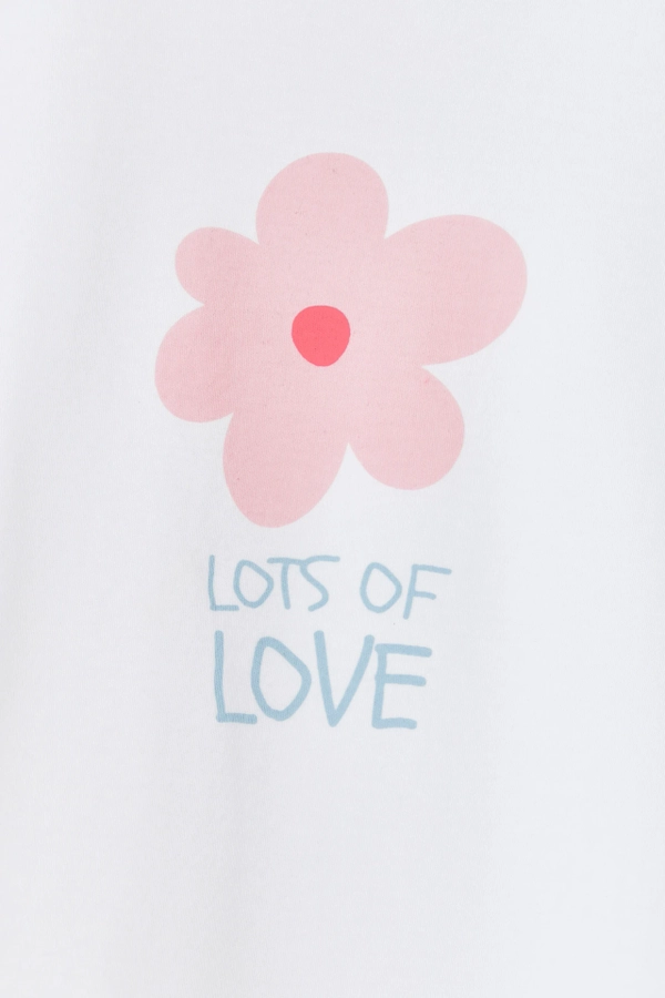 Flutter Short Sleeve Top with round necklace and flower printed at the front. Button at the back for easy fit. Made with pima cotton. Pattern view.