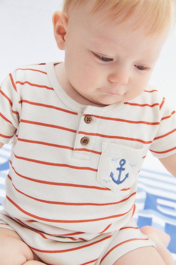 Striped Short Pocket Romper. Round necklace with buttons. Short sleeves and pocket at the front. Baby model view